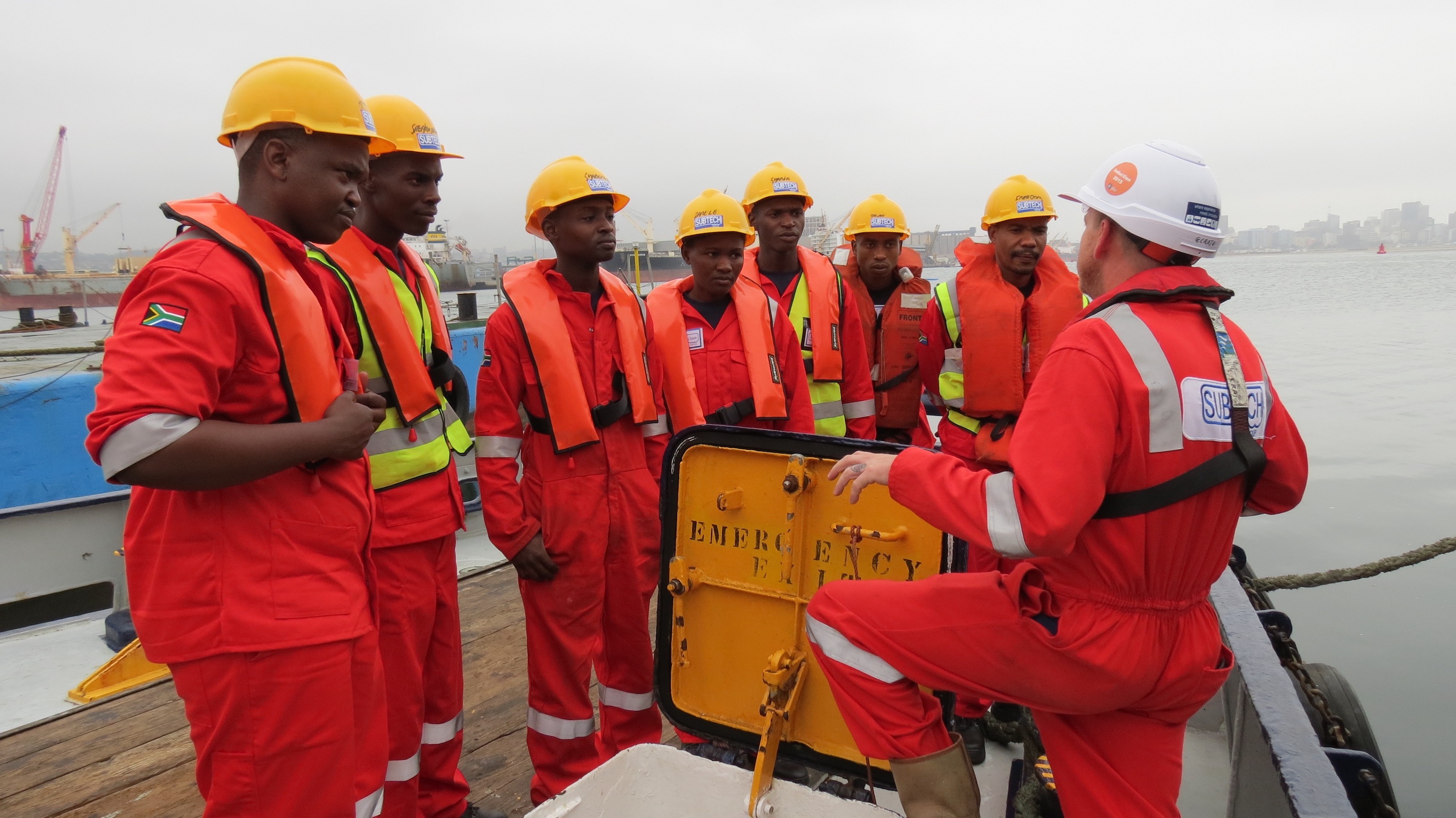 Eight men attending tool box talk onboard ship
