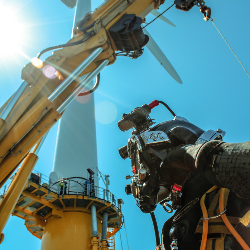 Man in diving gear with wind turbine in the background