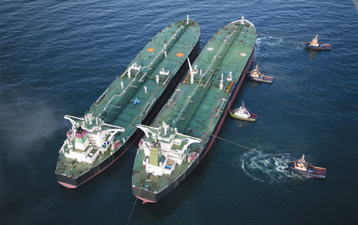 Ship-to-ship transfer at anchor with tugs