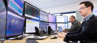 EDS employee looking at computer monitors