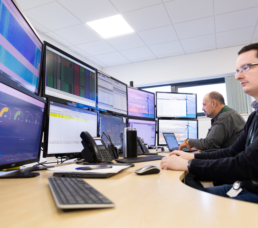 EDS employee looking at computer monitors